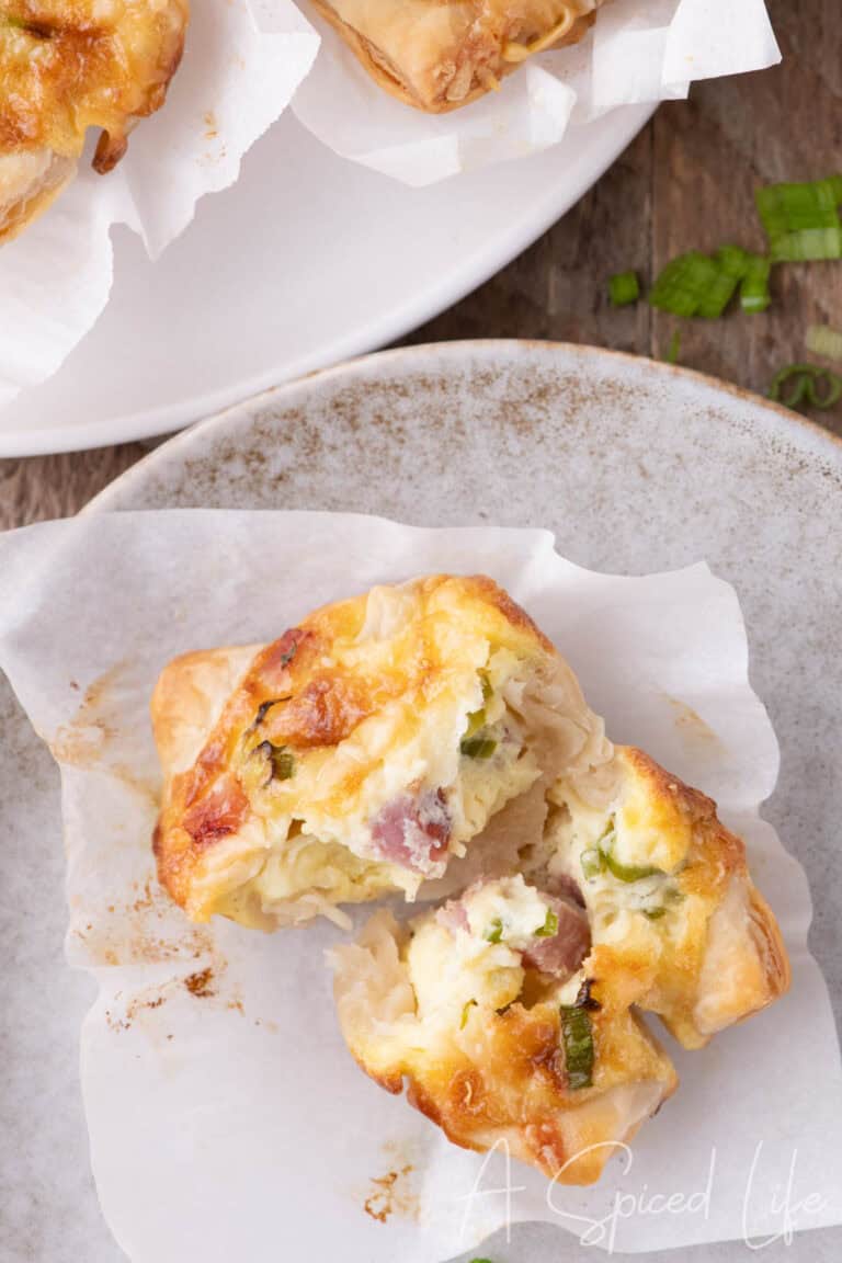 Overhead of mini quiche breakfast cups with golden tops in baking tray.