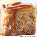 Close-up of a banana bread bar slice topped with thick salted caramel sauce dripping down the sides.