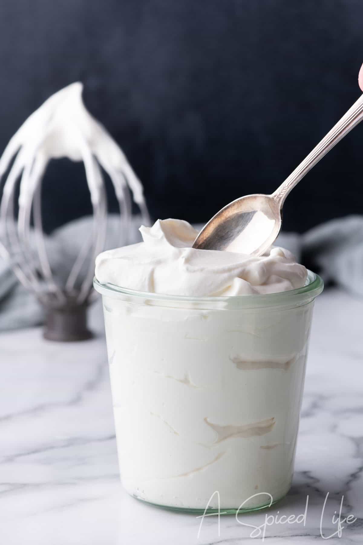 Close-up of fluffy Chantilly cream in a glass jar with soft peaks