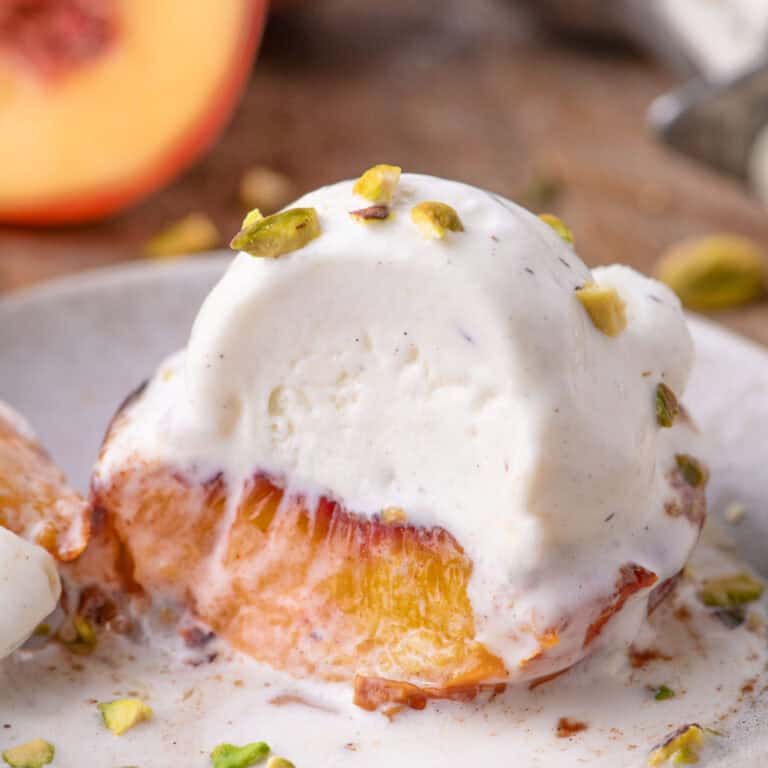 side shot of peach cut in half with melted ice cream