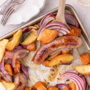 Overhead shot of sausage sweet potato sheet pan dinner with roasted apples, onions, and sage.
