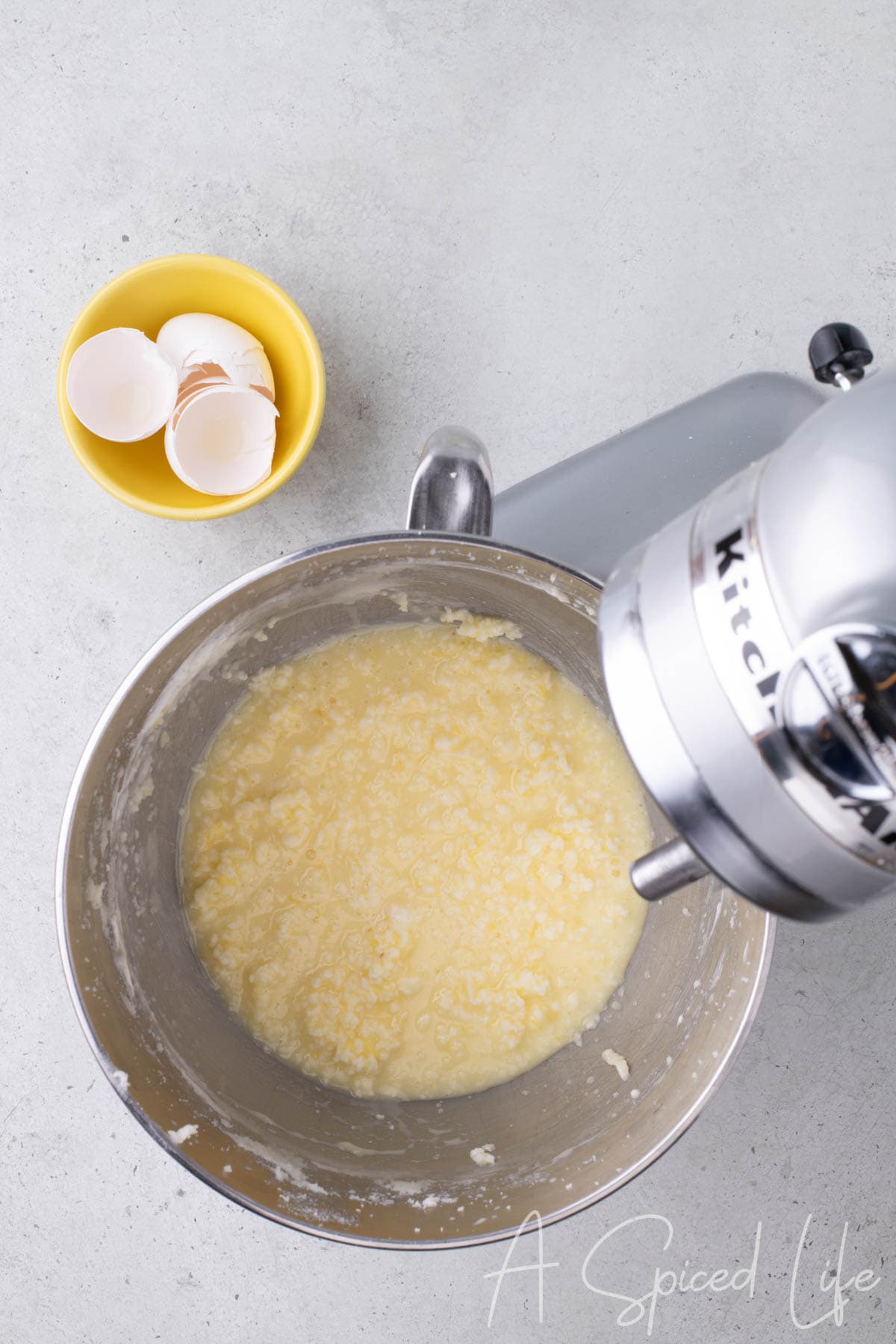 Eggs added to butter and yogurt mixture, batter looking curdled but well mixed