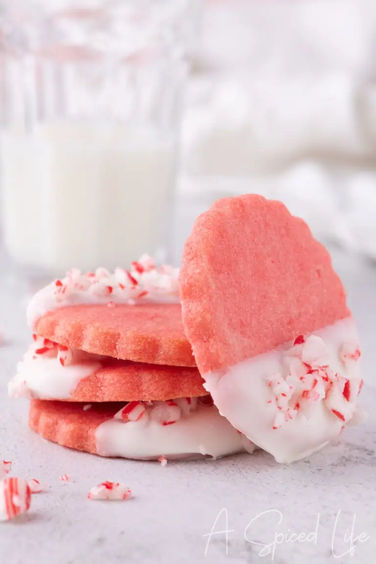 Stack of pink cookies dipped in white chocolate with crushed peppermint candy