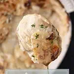 Cheesy potato gratin scooped from a casserole dish showing creamy layers inside