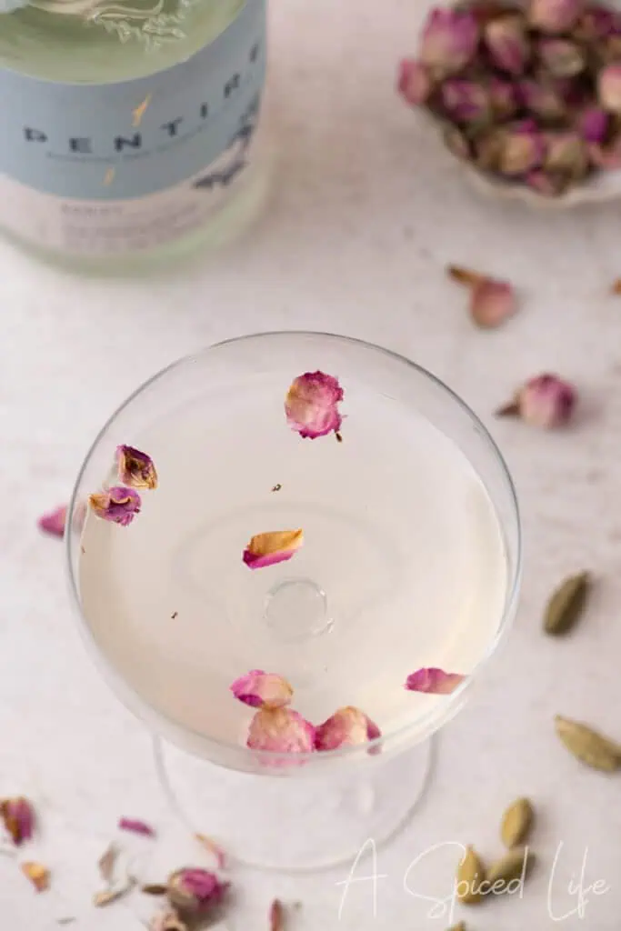 Rose petal mocktail in a coupe glass styled with flowers and soft pink tones for a romantic party setting