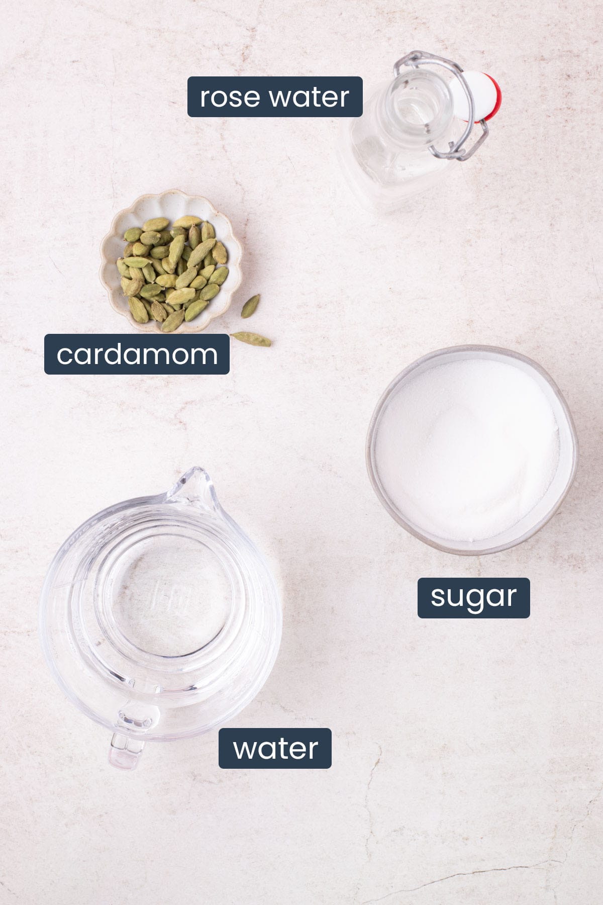 Rose water, cardamom pods, sugar, and water arranged for making rose cardamom simple syrup