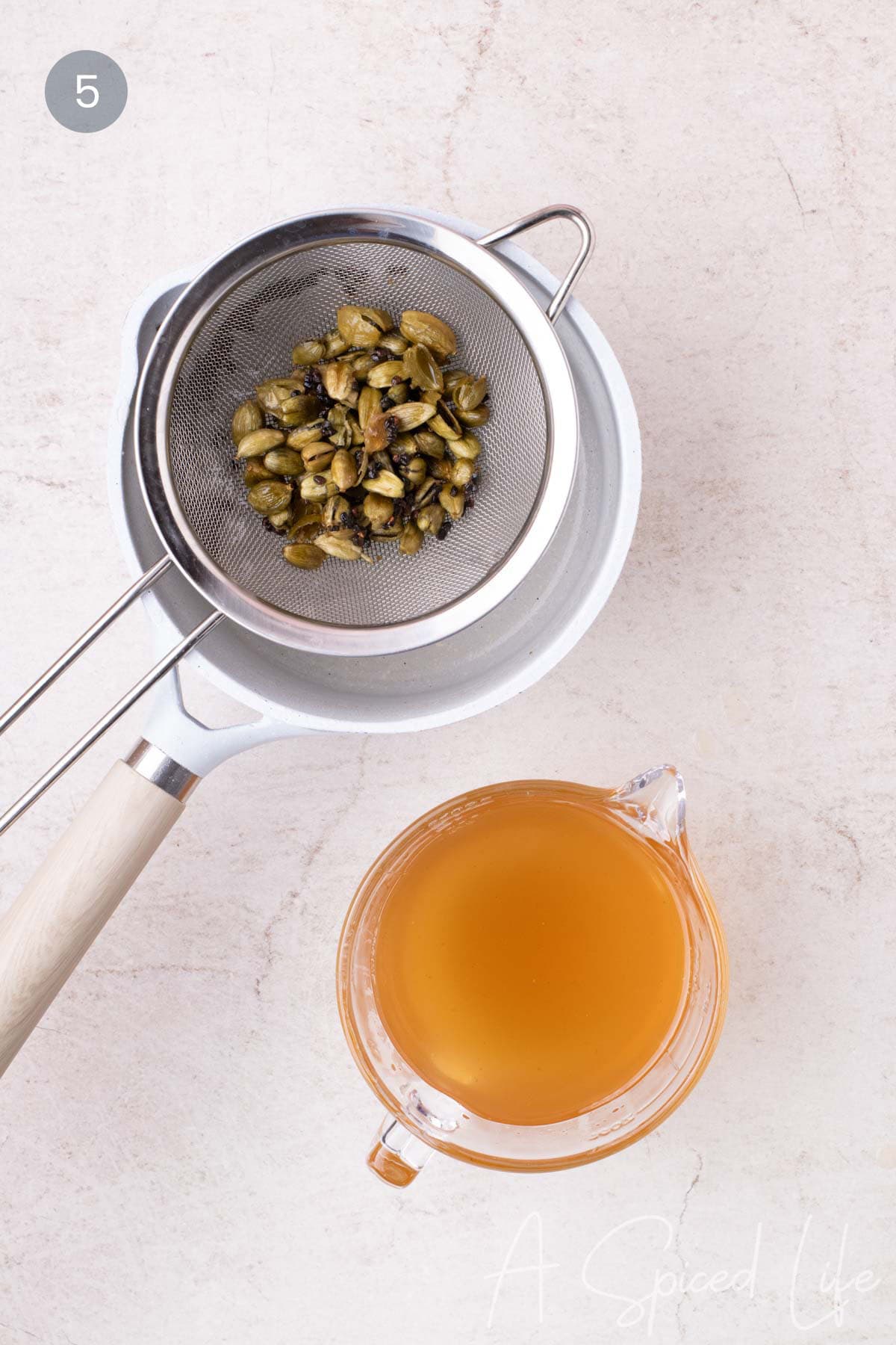 Freshly strained syrup cooling in a glass measuring cup