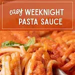 Close-up spaghetti noodles covered in red sauce with basil