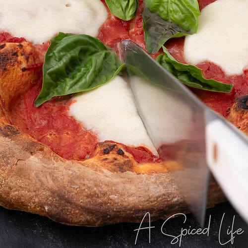 Cutting homemade Margherita pizza made with store-bought pizza dough