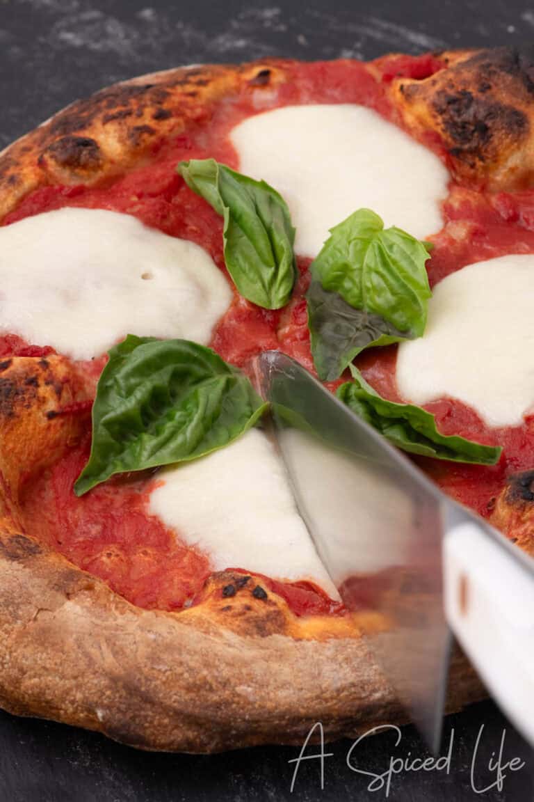 Cutting homemade Margherita pizza made with store-bought pizza dough