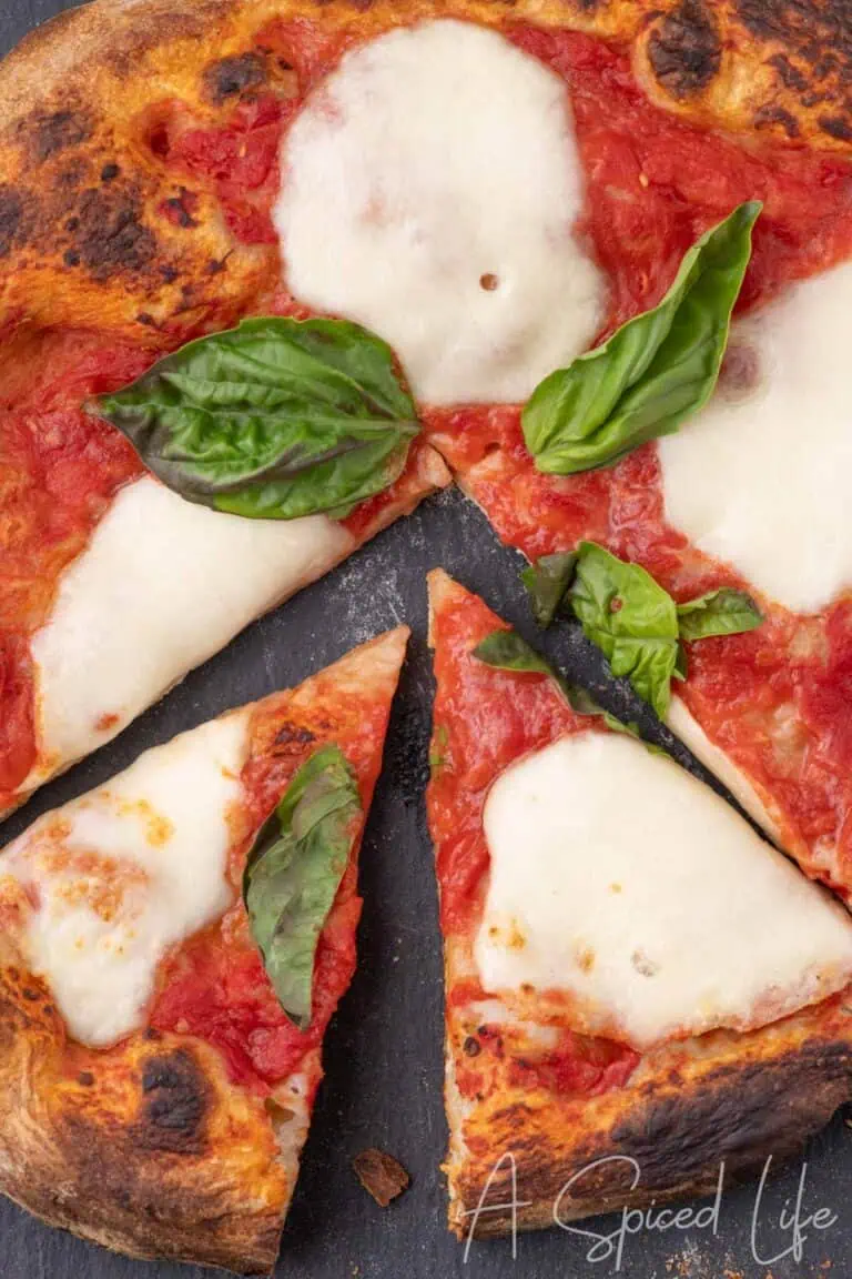 Neapolitan Margherita pizza sliced with blistered crust and melted mozzarella