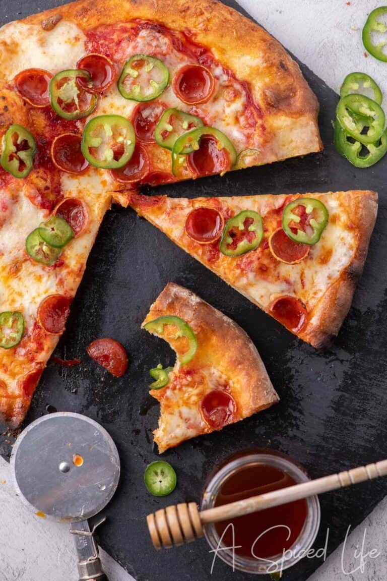 Slices of Diavola pizza topped with pepperoni, jalapeños, and mozzarella.