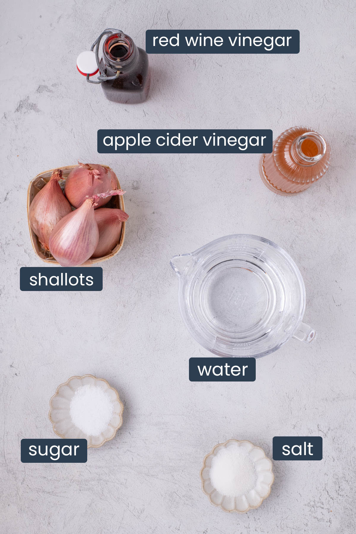 Ingredients for pickled shallots including vinegar, shallots, salt, sugar, and water