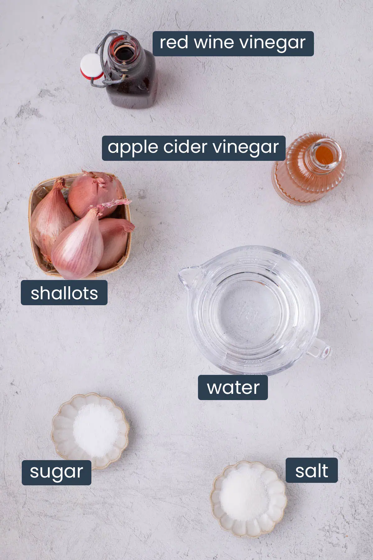 Ingredients for pickled shallots including vinegar, shallots, salt, sugar, and water