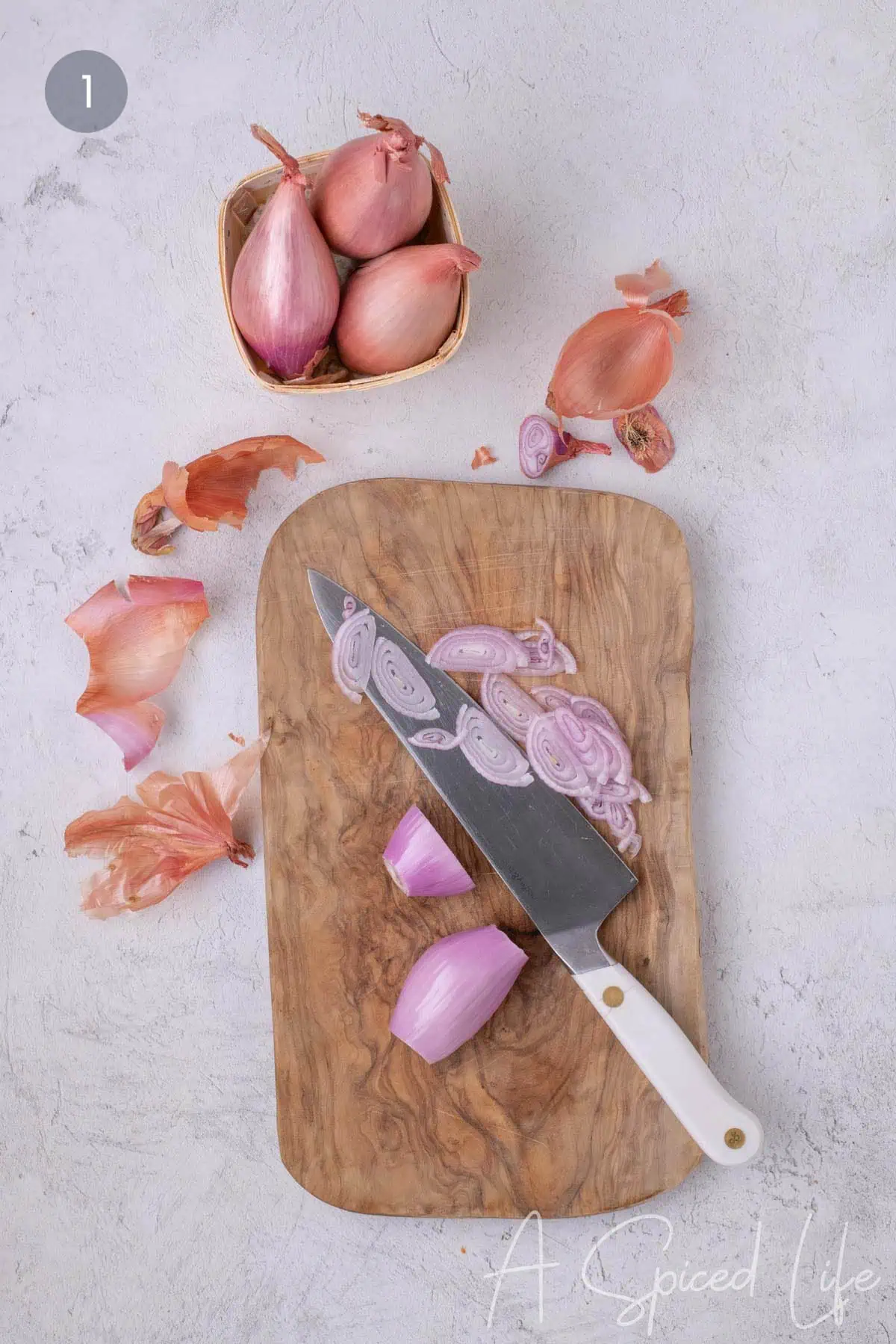 Cutting shallots into thin slices on a wooden cutting board