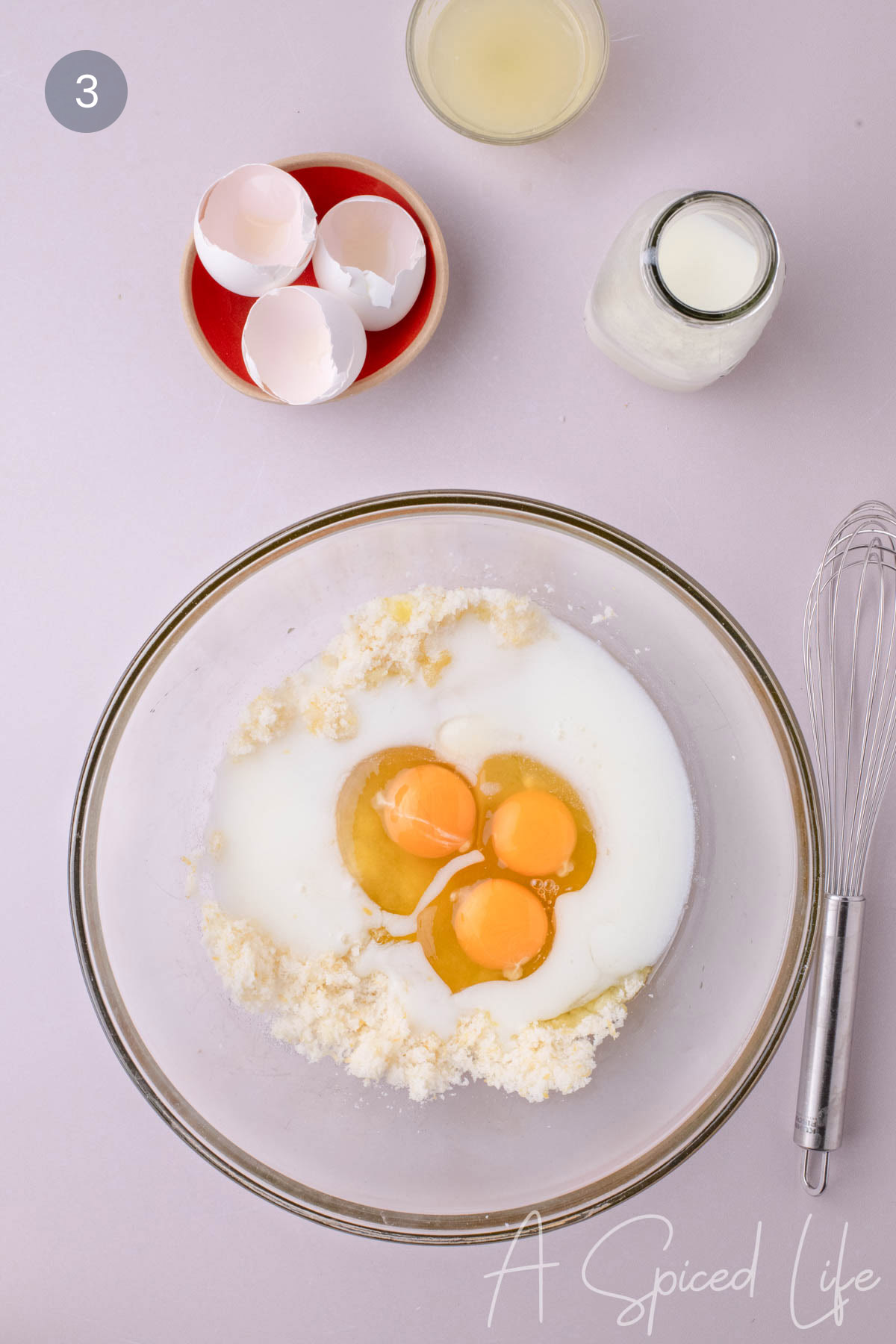 Eggs, buttermilk, and lemon juice added to lemon sugar in a mixing bowl