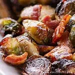 Roasted Brussels sprouts with bacon and hot honey glaze on a white plate.