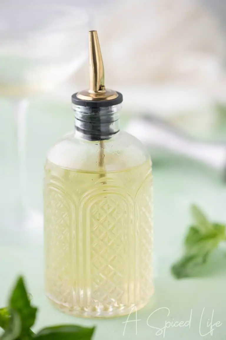 Close-up of homemade basil syrup in a glass bottle with a pour spout