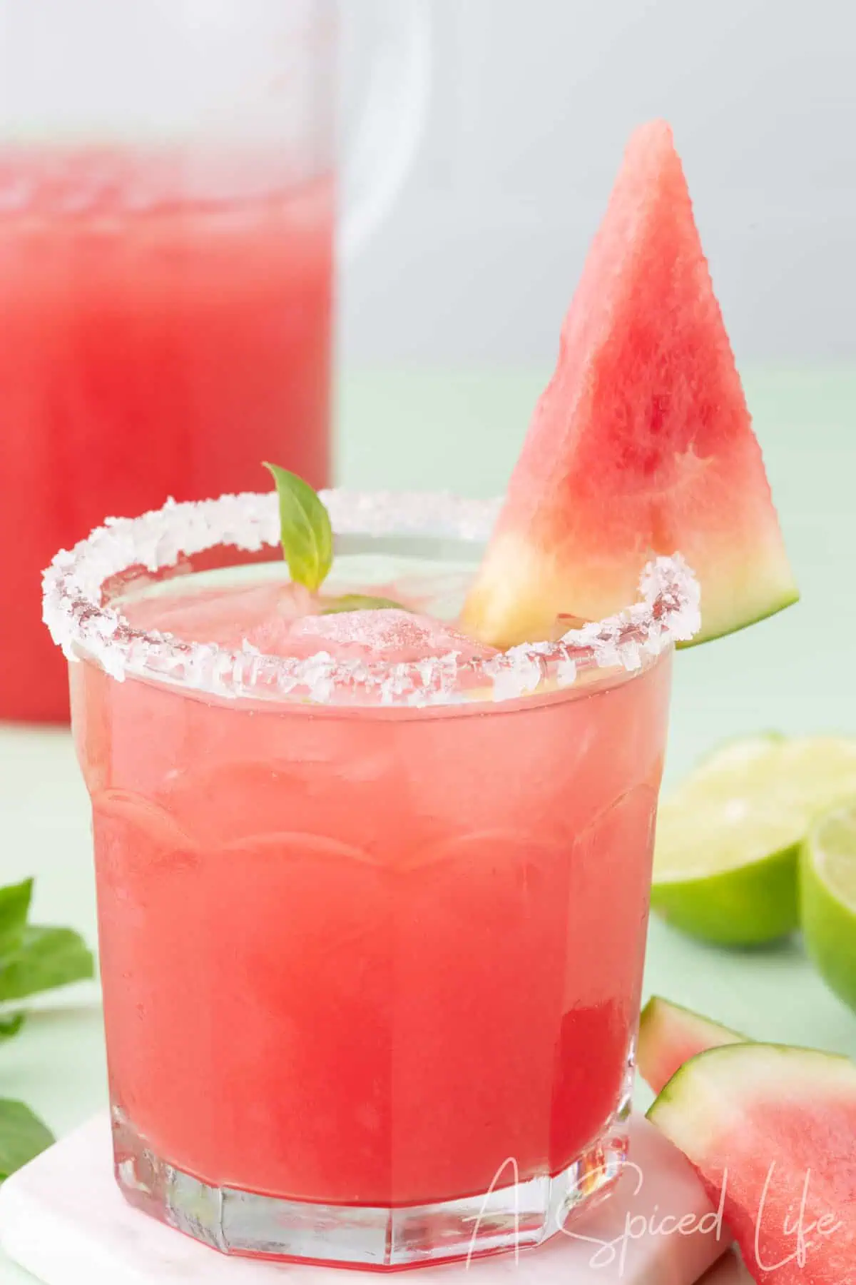 Watermelon basil margarita with a sugared rim and fresh watermelon garnish