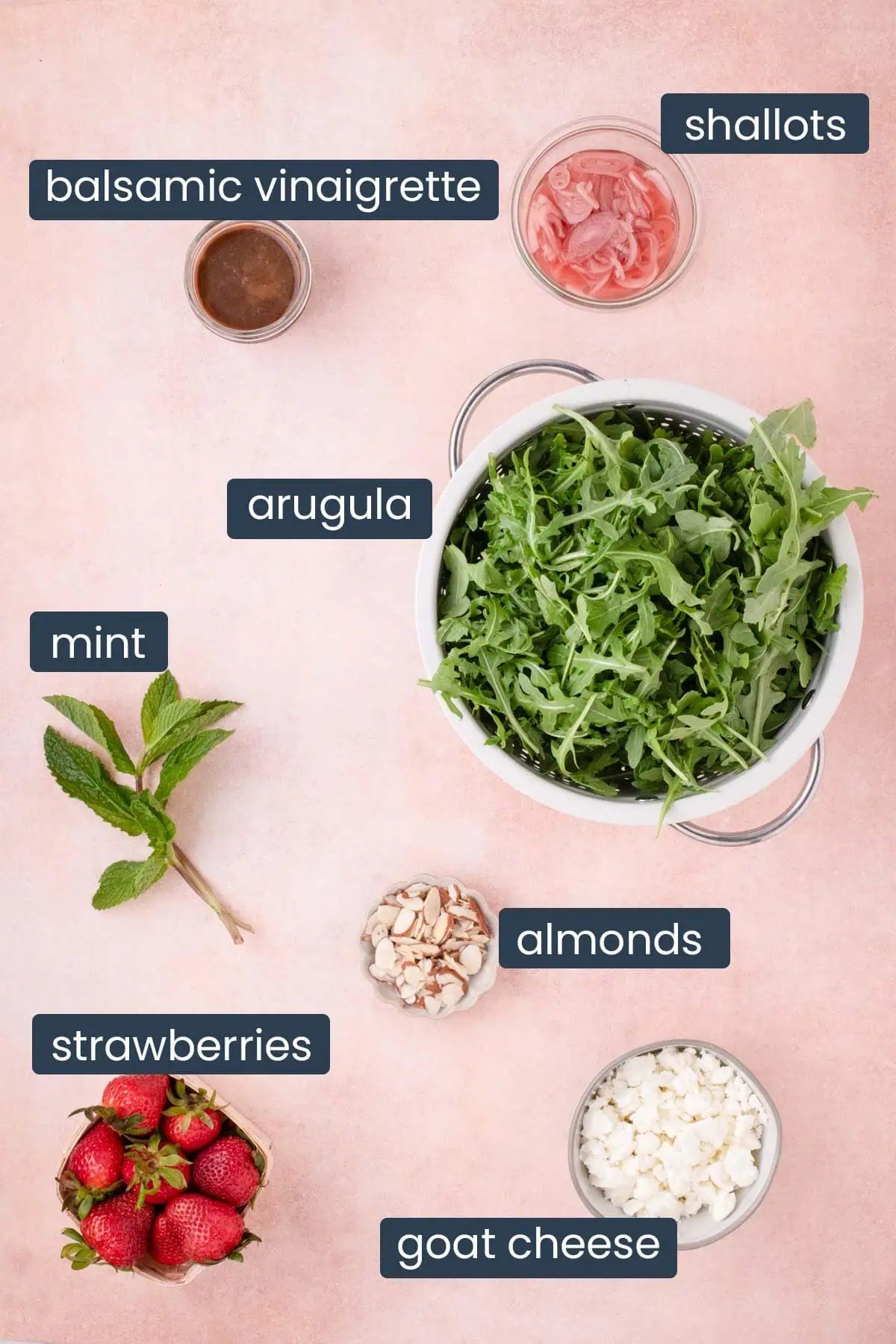 Arugula, strawberries, goat cheese, almonds, mint, and balsamic vinaigrette arranged for a salad