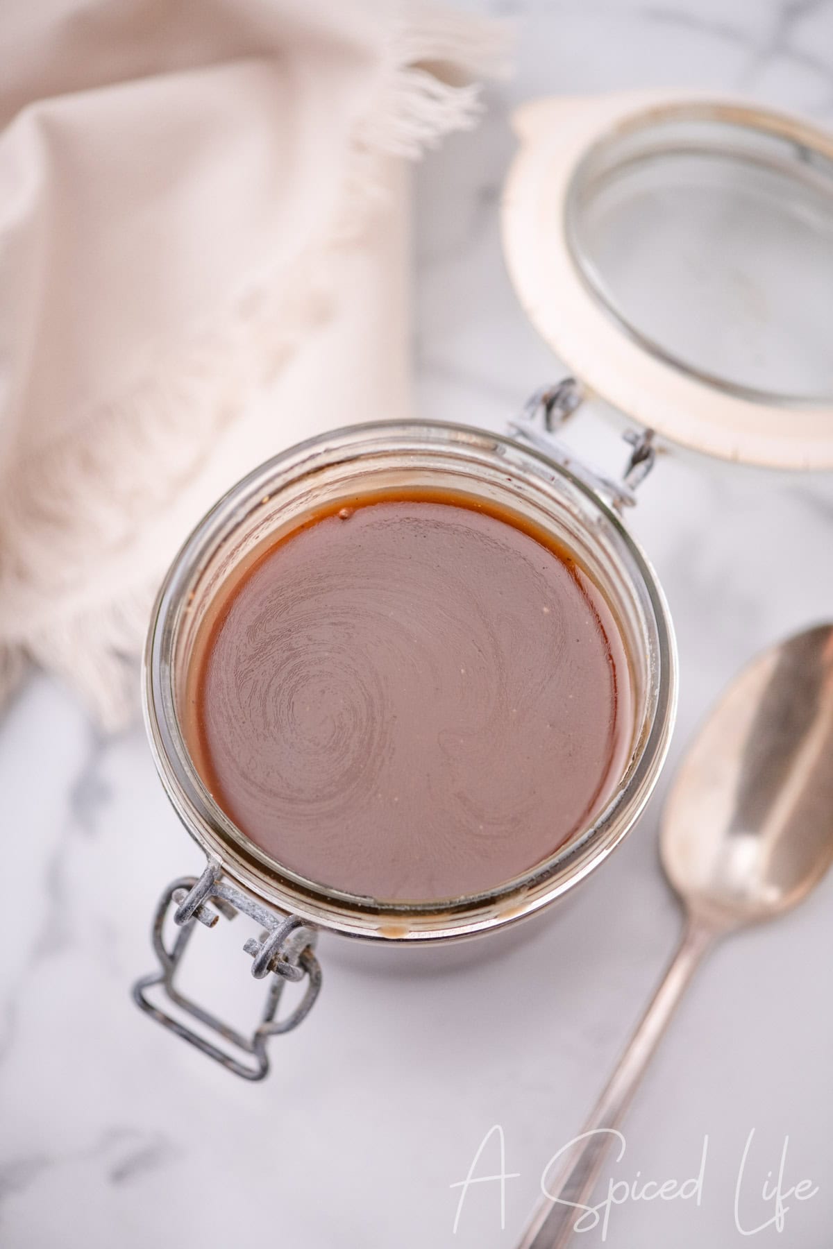 Smooth, emulsified balsamic dressing with a glossy texture in a jar.