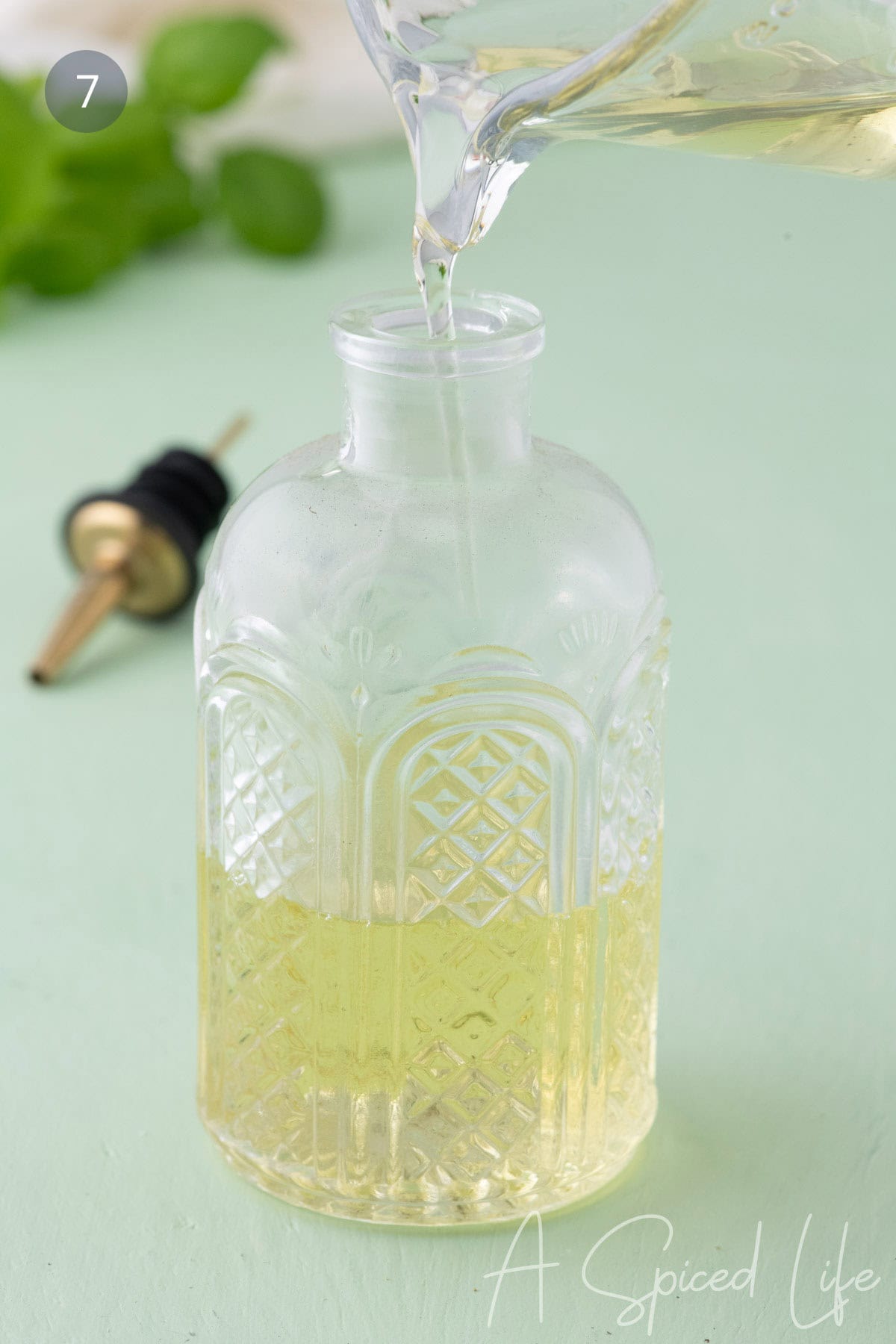 Pouring basil simple syrup into a glass bottle for storage