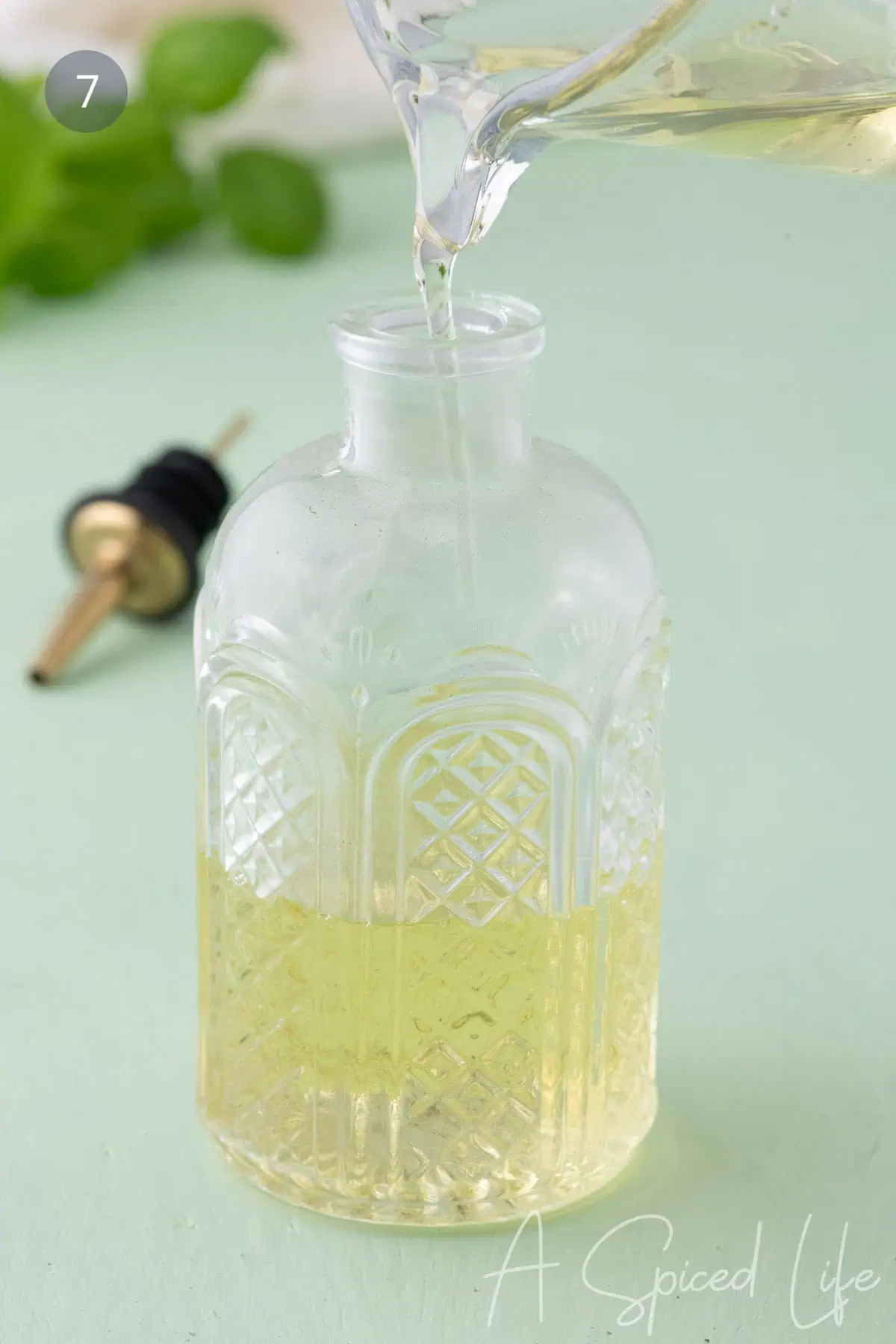 Pouring basil simple syrup into a glass bottle for storage