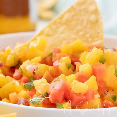 bowl of tropical fruit salsa with mango pineapple papaya and tortilla chips