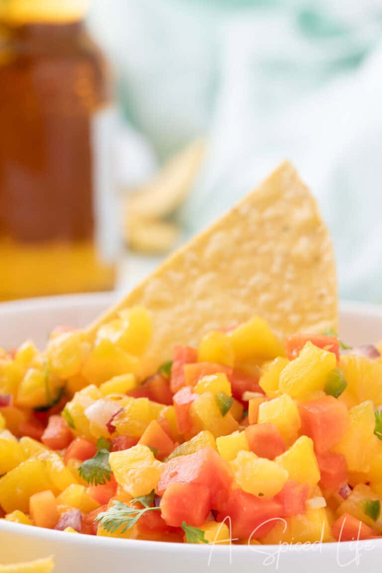 bowl of tropical fruit salsa with mango pineapple papaya and tortilla chips