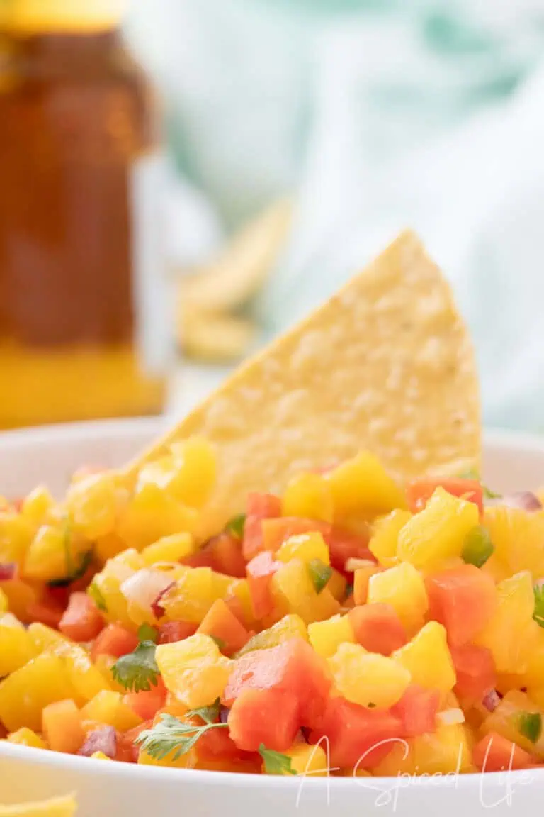 bowl of tropical fruit salsa with mango pineapple papaya and tortilla chips
