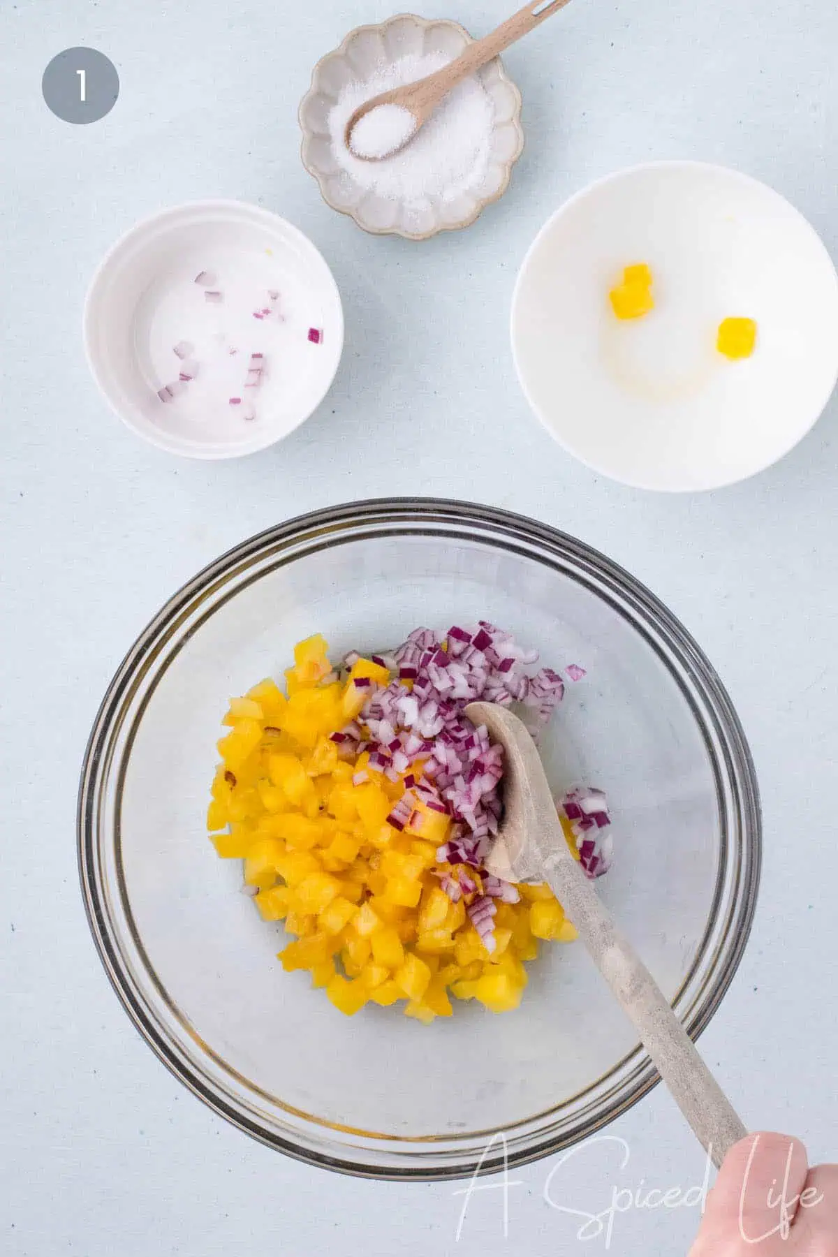 diced red onion soaking with lime juice and pineapple in a bowl to soften before mixing salsa