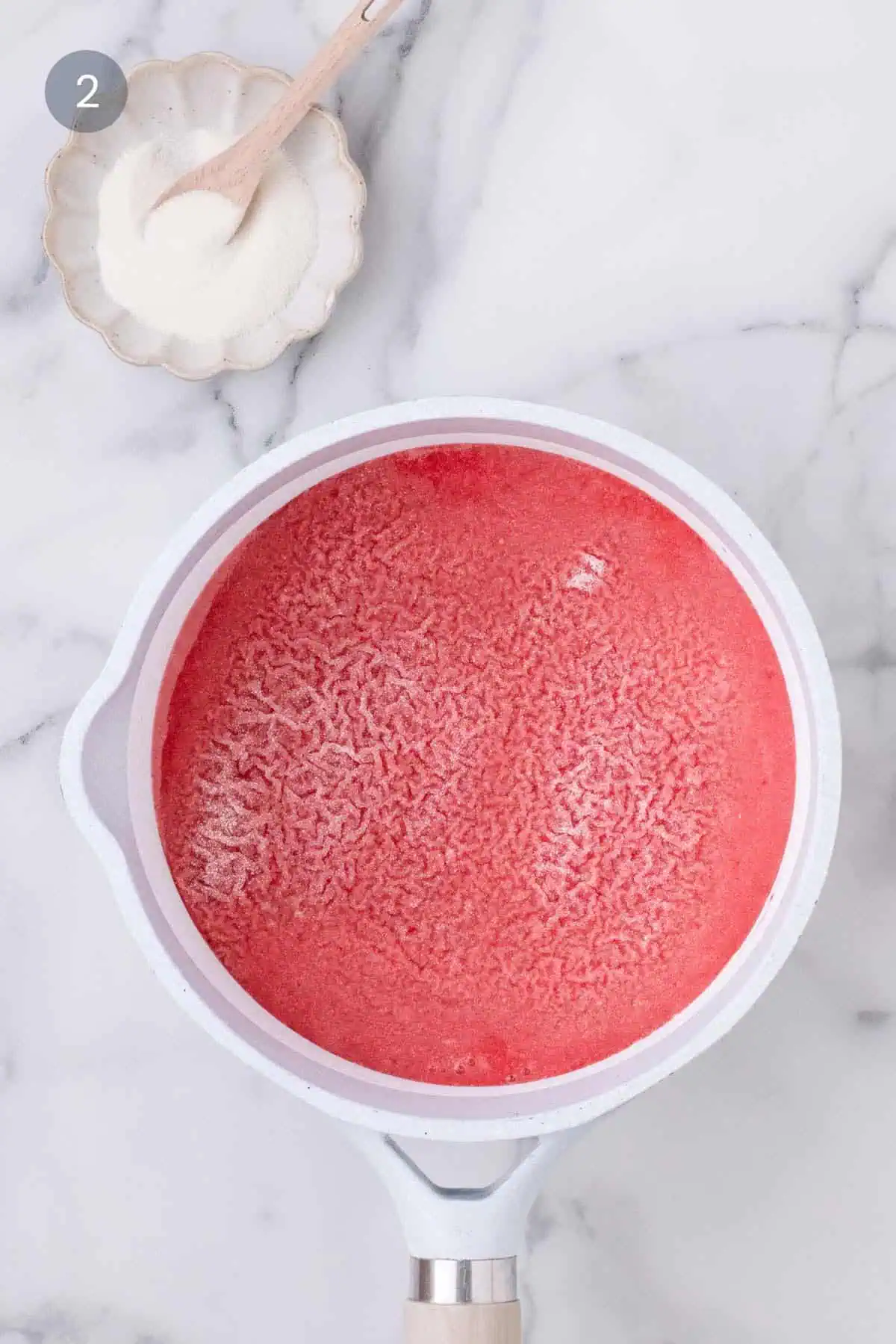 Gelatin hydrating over strawberry purée for layered coconut panna cotta.