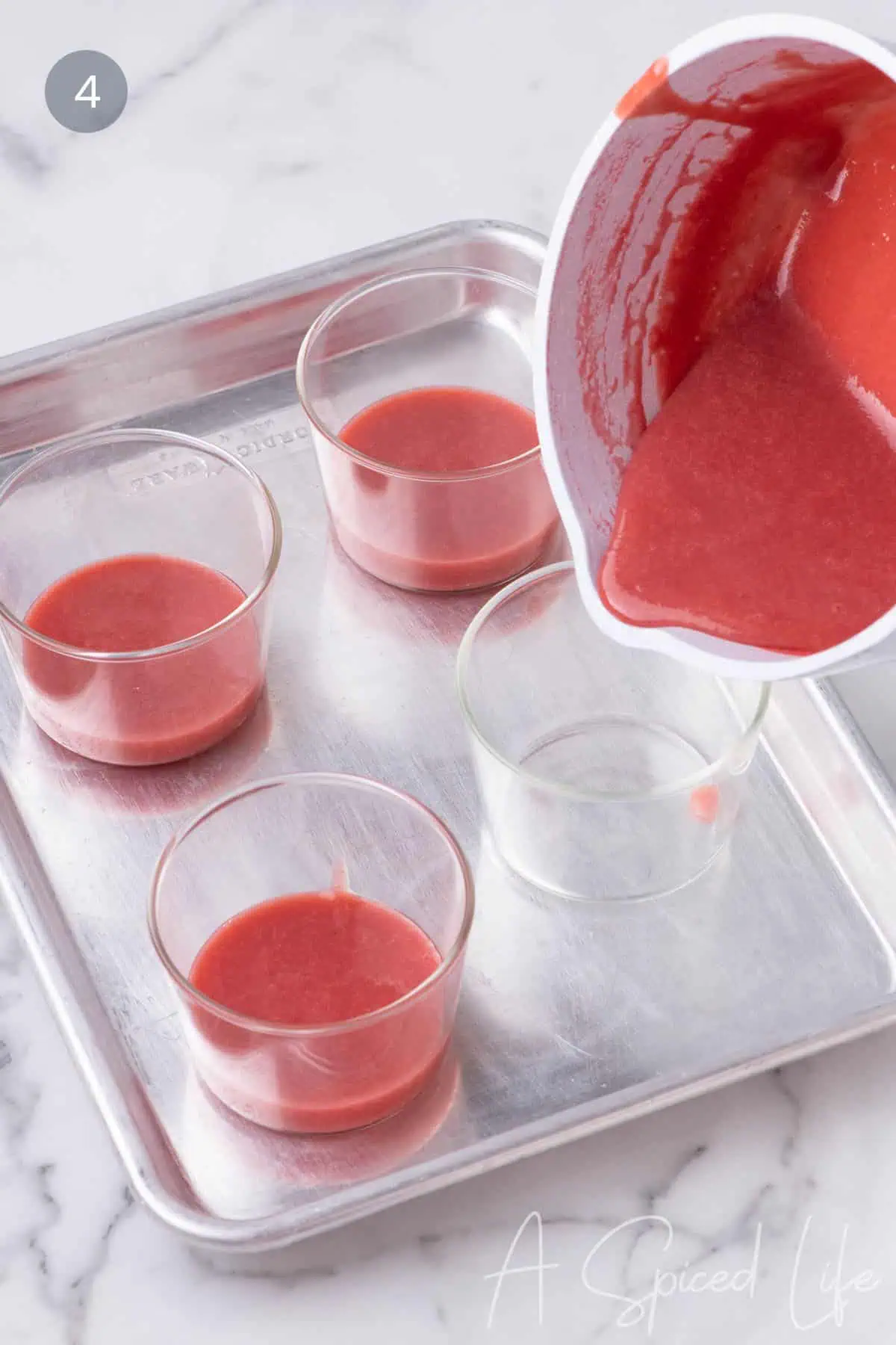 Pouring strawberry puree into glass jars