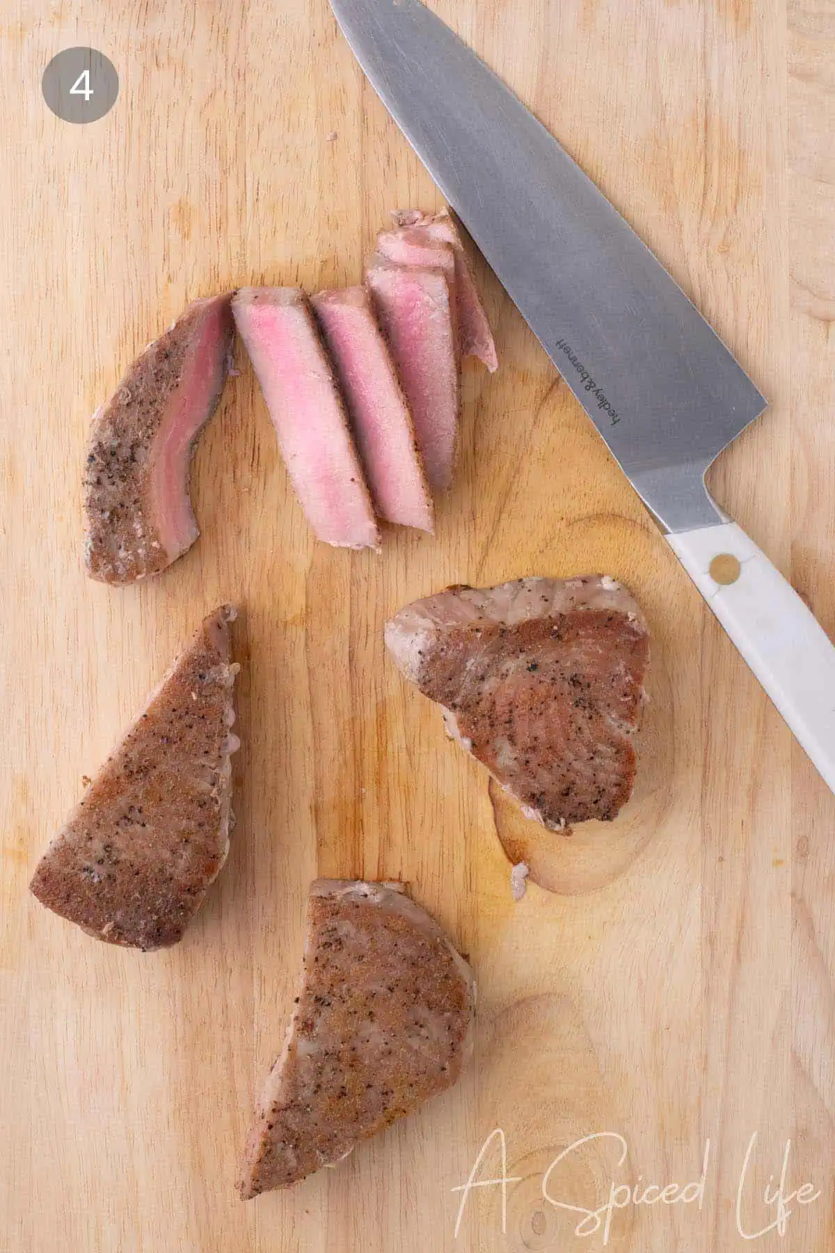 Sliced medium-rare seared ahi tuna on a cutting board