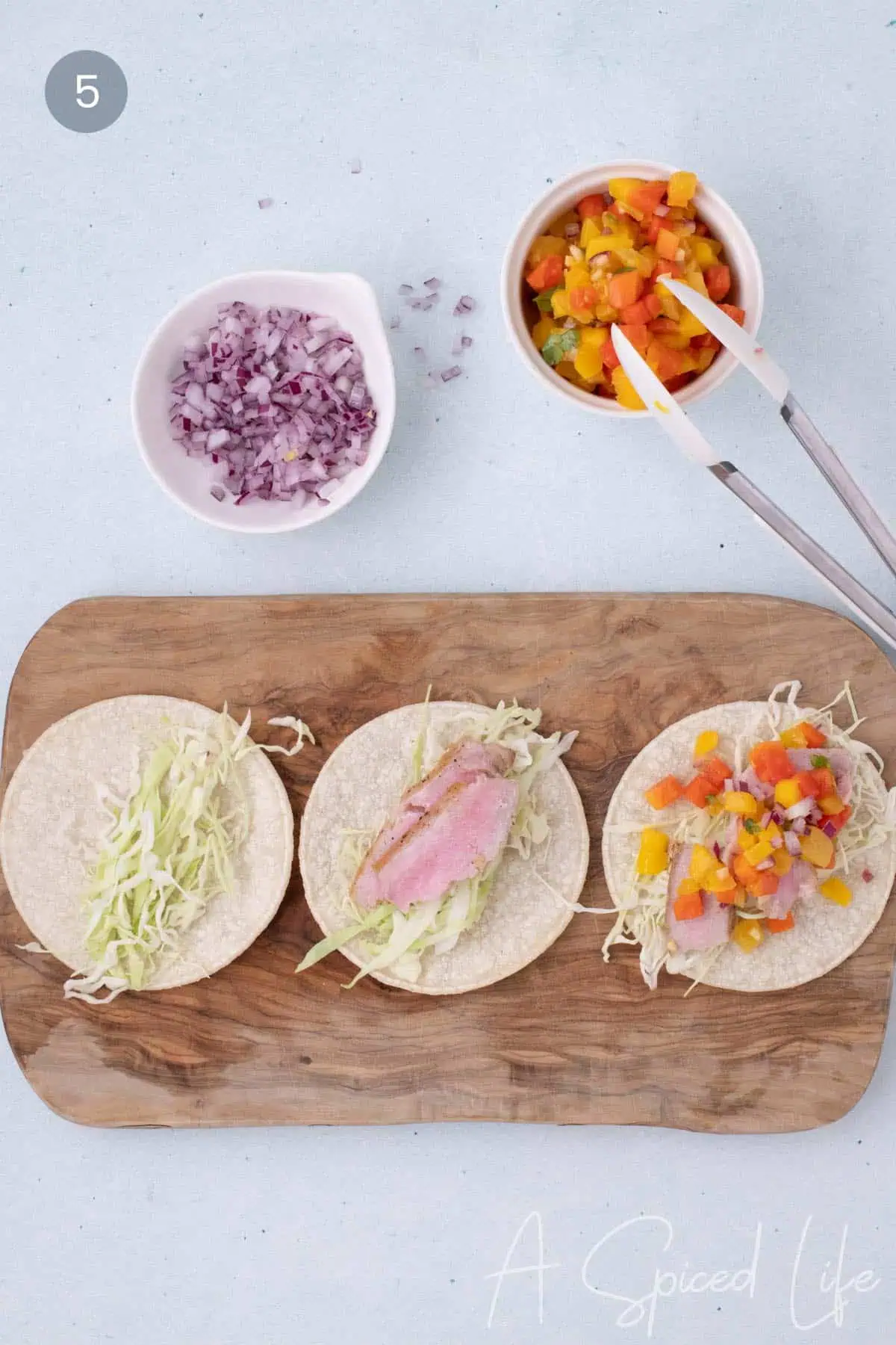 Assembling ahi tuna tacos with cabbage and mango papaya salsa