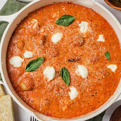 Chicken and ricotta meatballs simmered in creamy fire-roasted tomato sauce topped with basil, Parmesan, and dollops of ricotta.