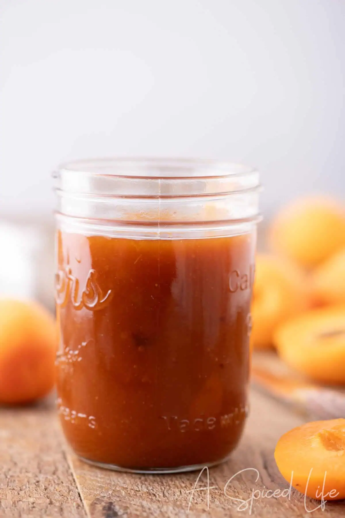 Homemade apricot BBQ sauce in a glass jar with fresh apricots