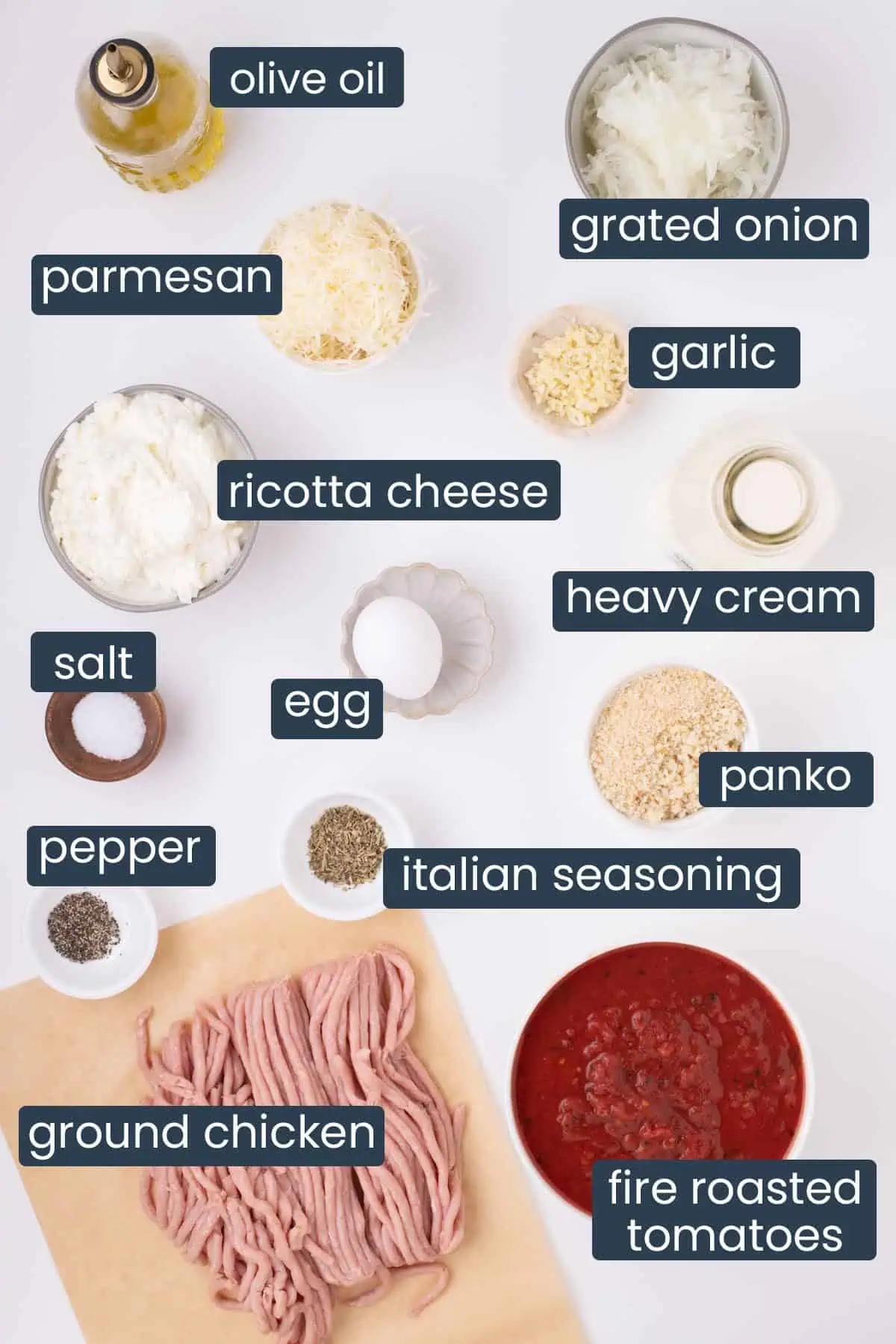 Ingredients for chicken and ricotta meatballs including ground chicken, ricotta cheese, Parmesan, panko breadcrumbs, fire-roasted tomatoes, onion, garlic, and seasonings arranged on a countertop.