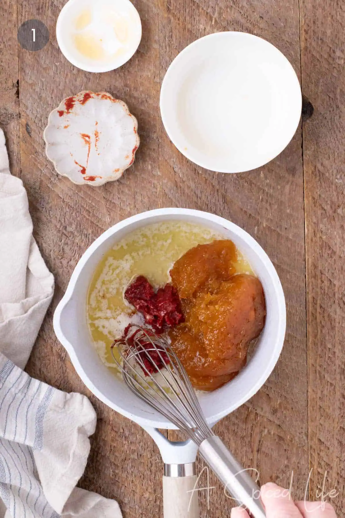 Apricot preserves, butter, and tomato paste in a saucepan for making apricot BBQ sauce