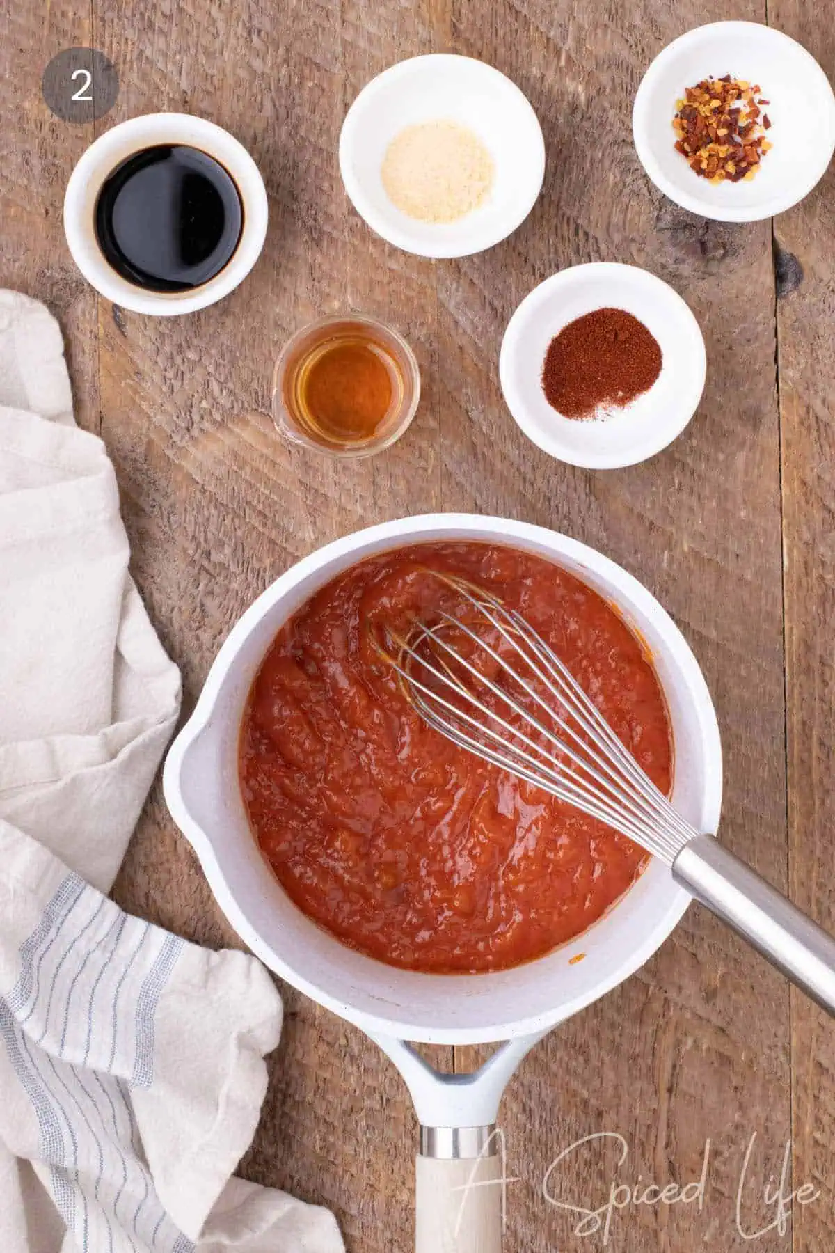 Seasonings and liquids being added to apricot BBQ sauce mixture in a saucepan