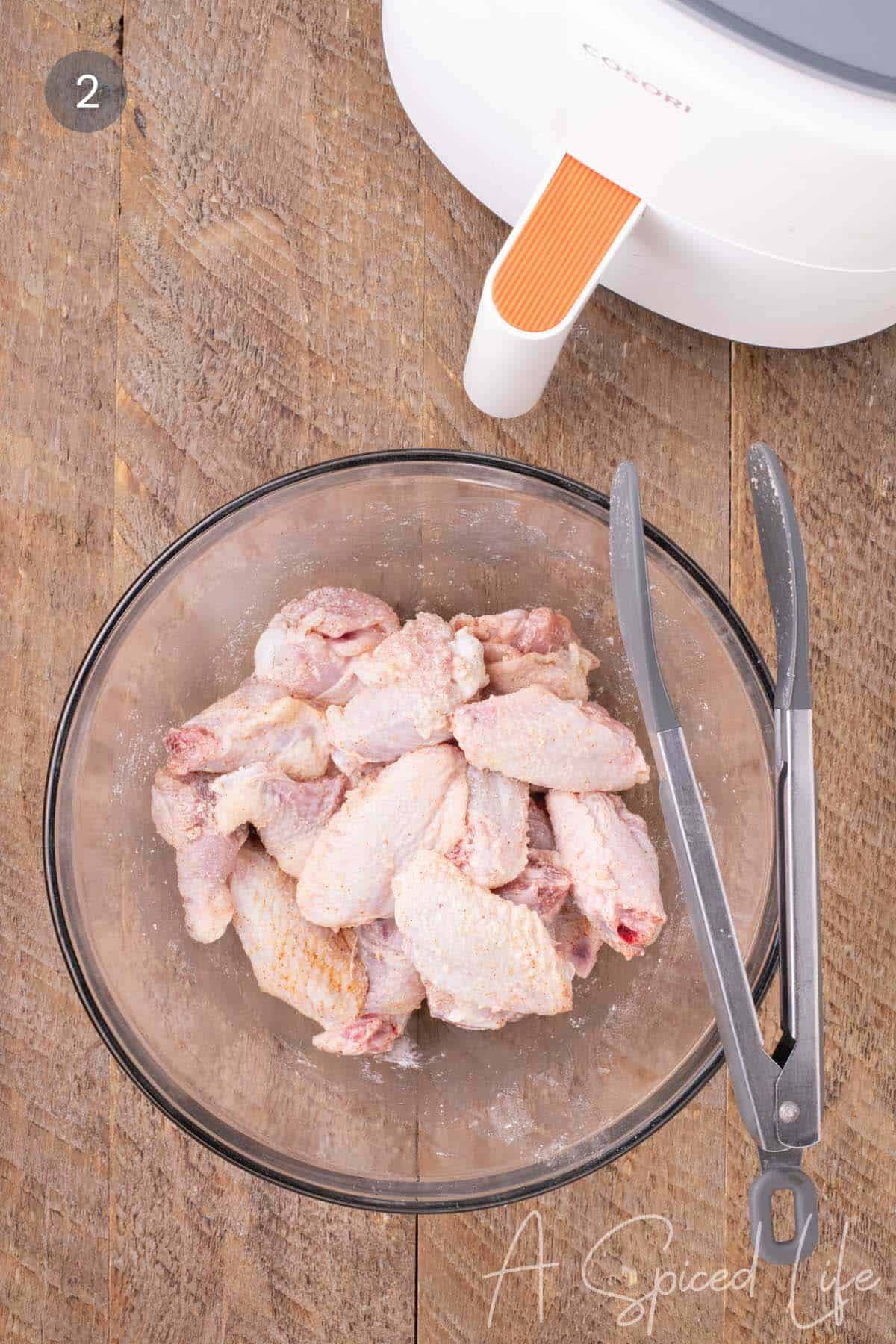 Seasoned chicken wings coated with baking powder mixture before air frying.
