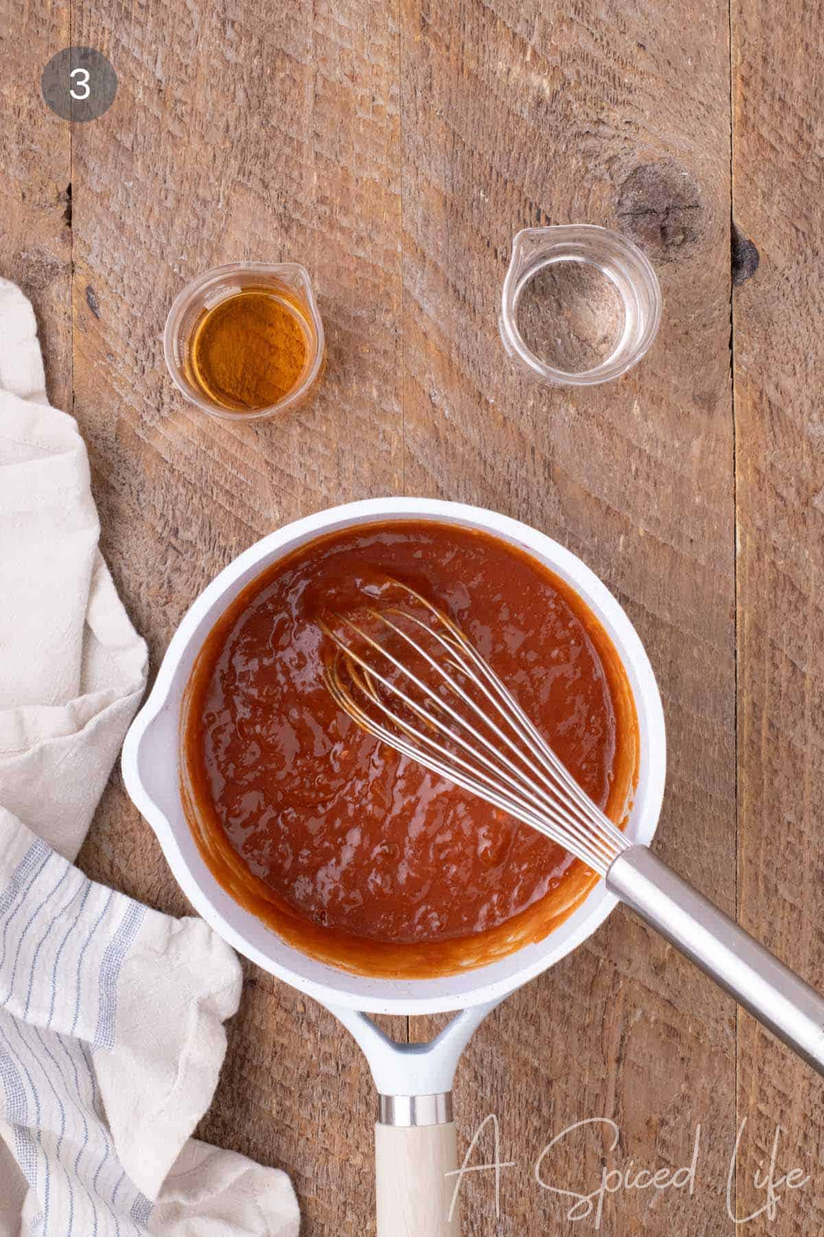 Homemade apricot barbeque sauce being whisked together in a saucepan