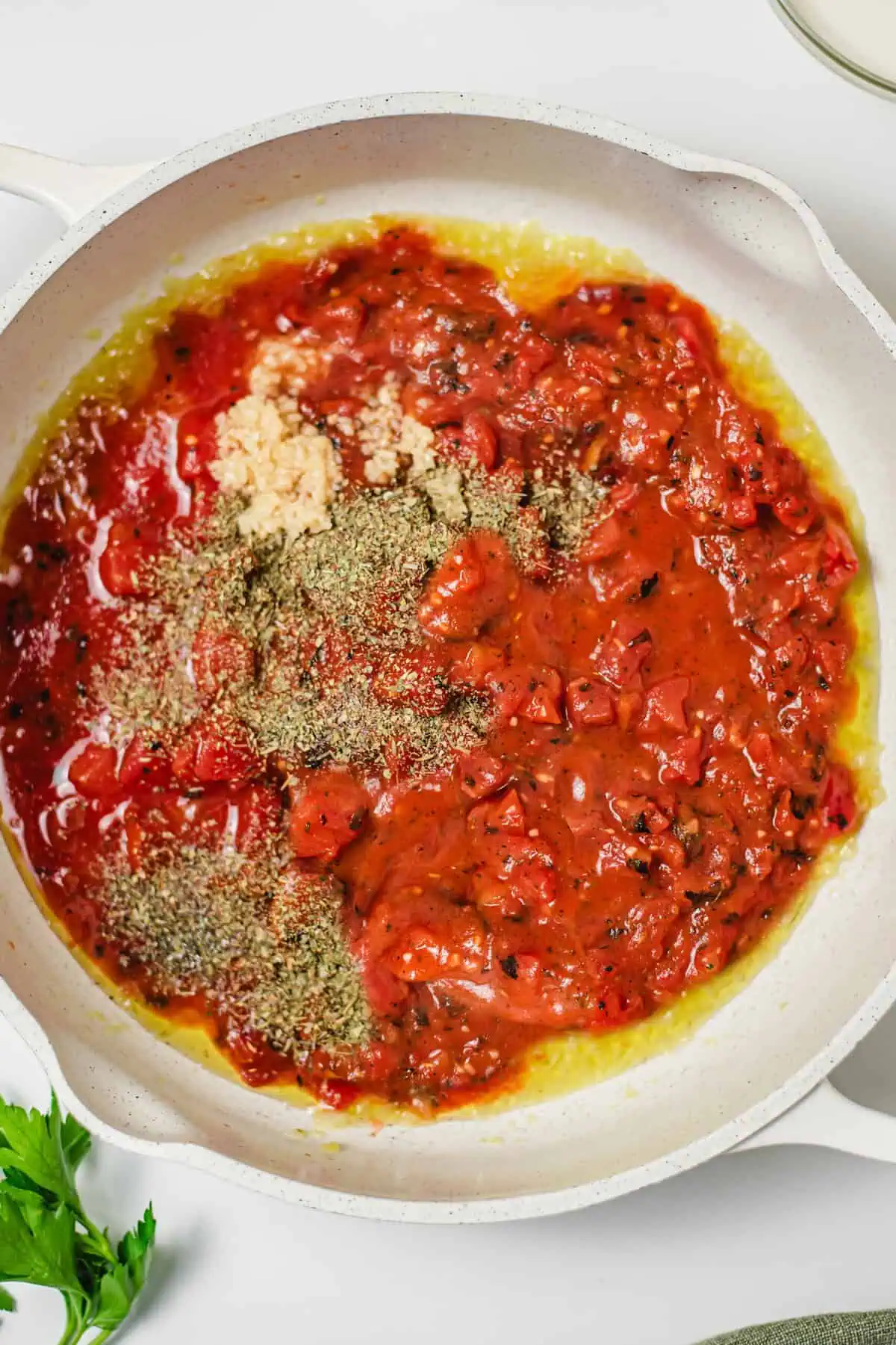 Fire-roasted tomatoes, garlic, and Italian seasoning added to a skillet with sautéed onion.