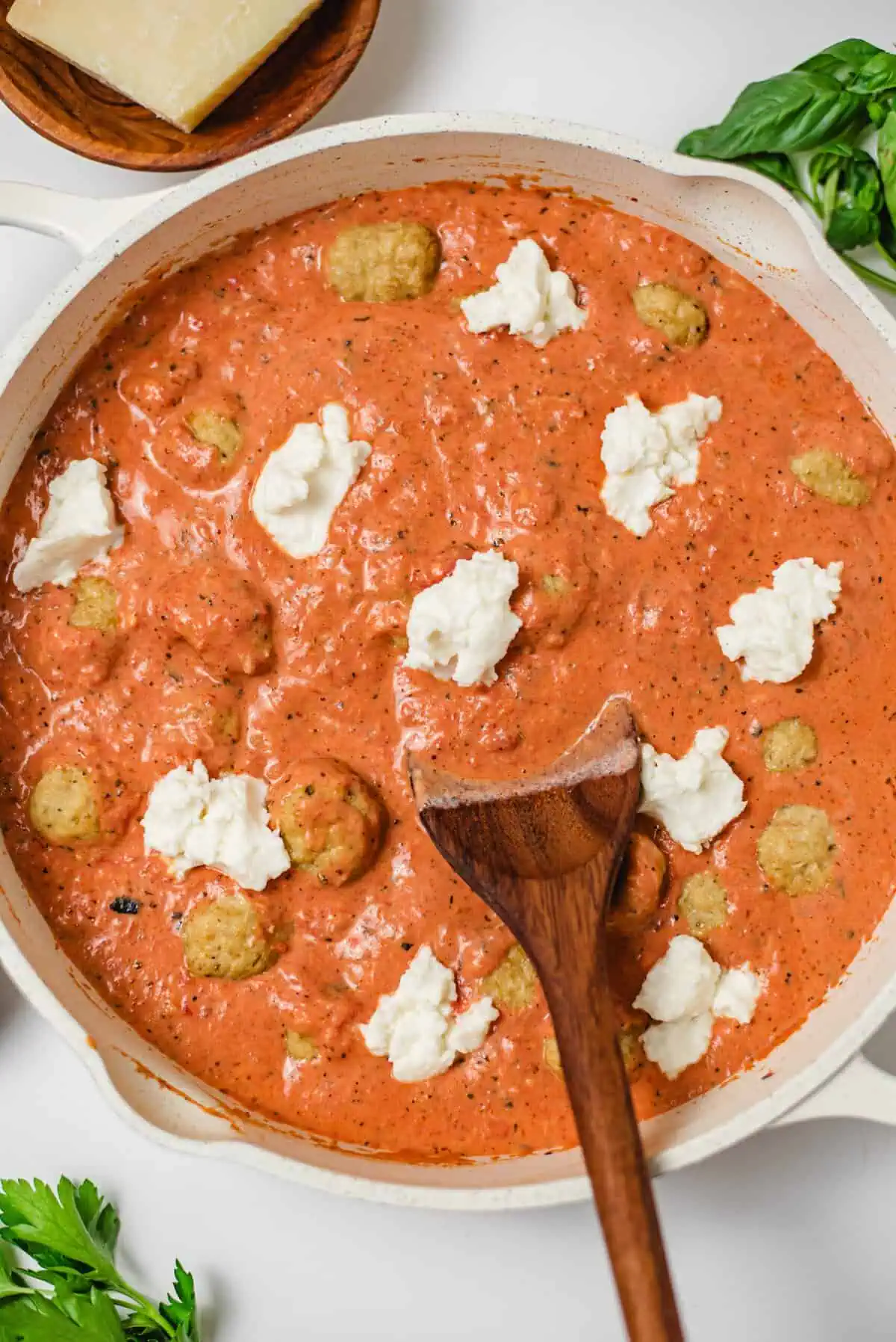 Baked chicken meatballs nestled in creamy tomato sauce with dollops of ricotta.