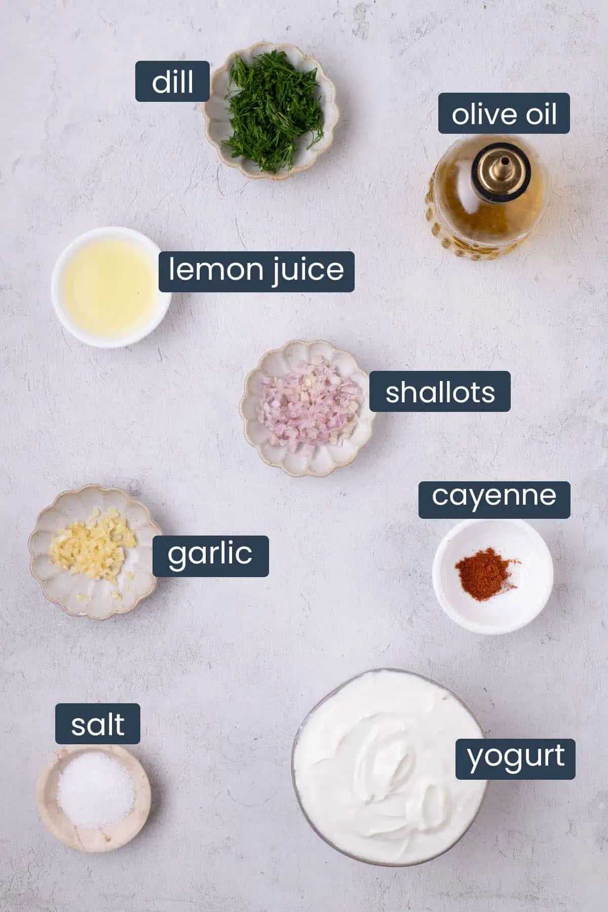 Ingredients for dill Greek yogurt dip, including Greek yogurt, fresh dill, lemon juice, shallot, garlic, olive oil, cayenne, and salt.