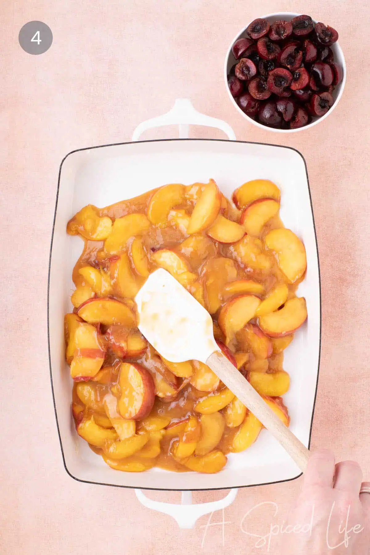 Transferring the peach filling to a baking dish for cherry and peach dessert