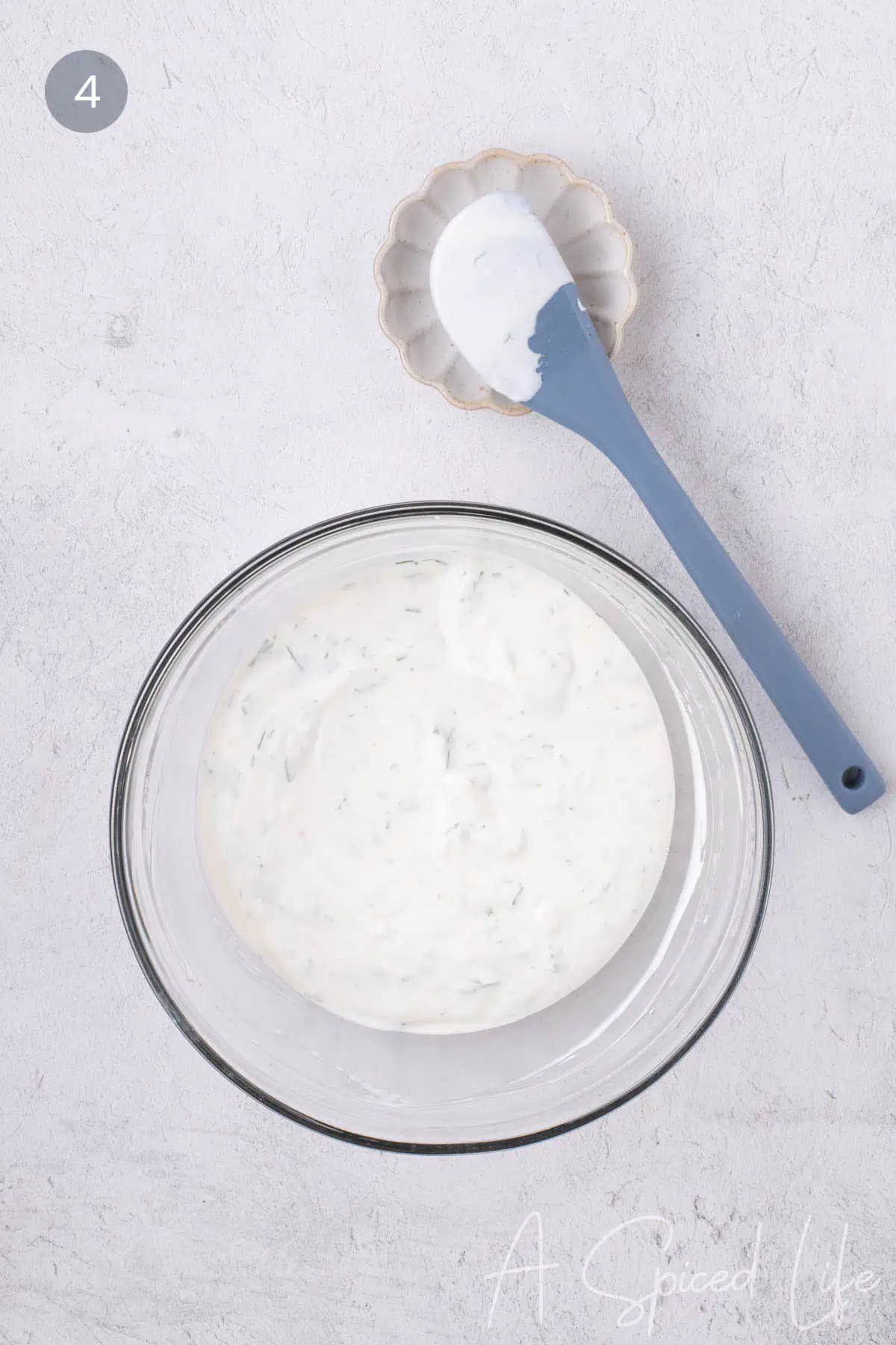 Creamy Greek yogurt dip with dill stirred until smooth in a glass bowl