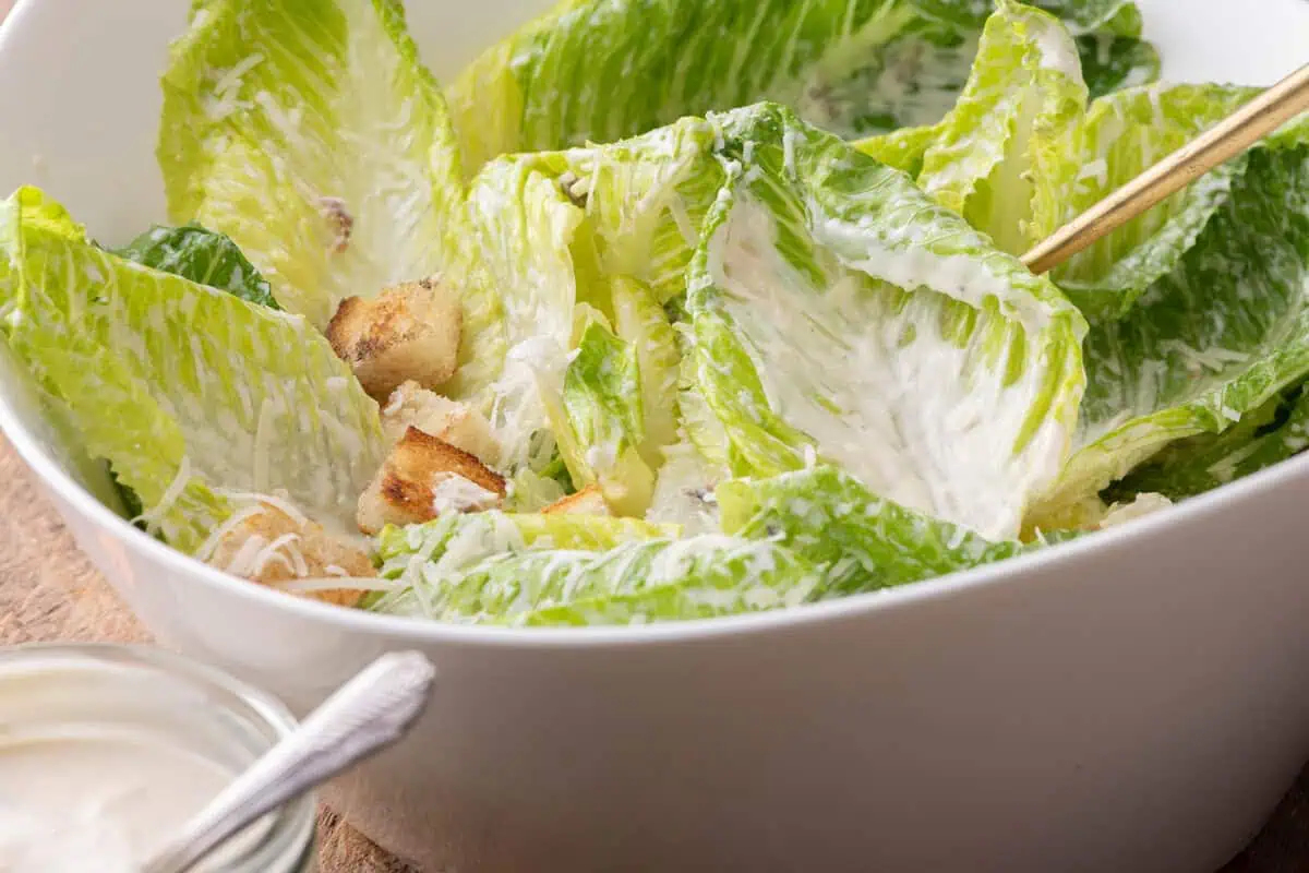 Close-up of a lighter Caesar salad with romaine leaves, croutons, Parmesan, and creamy dressing.