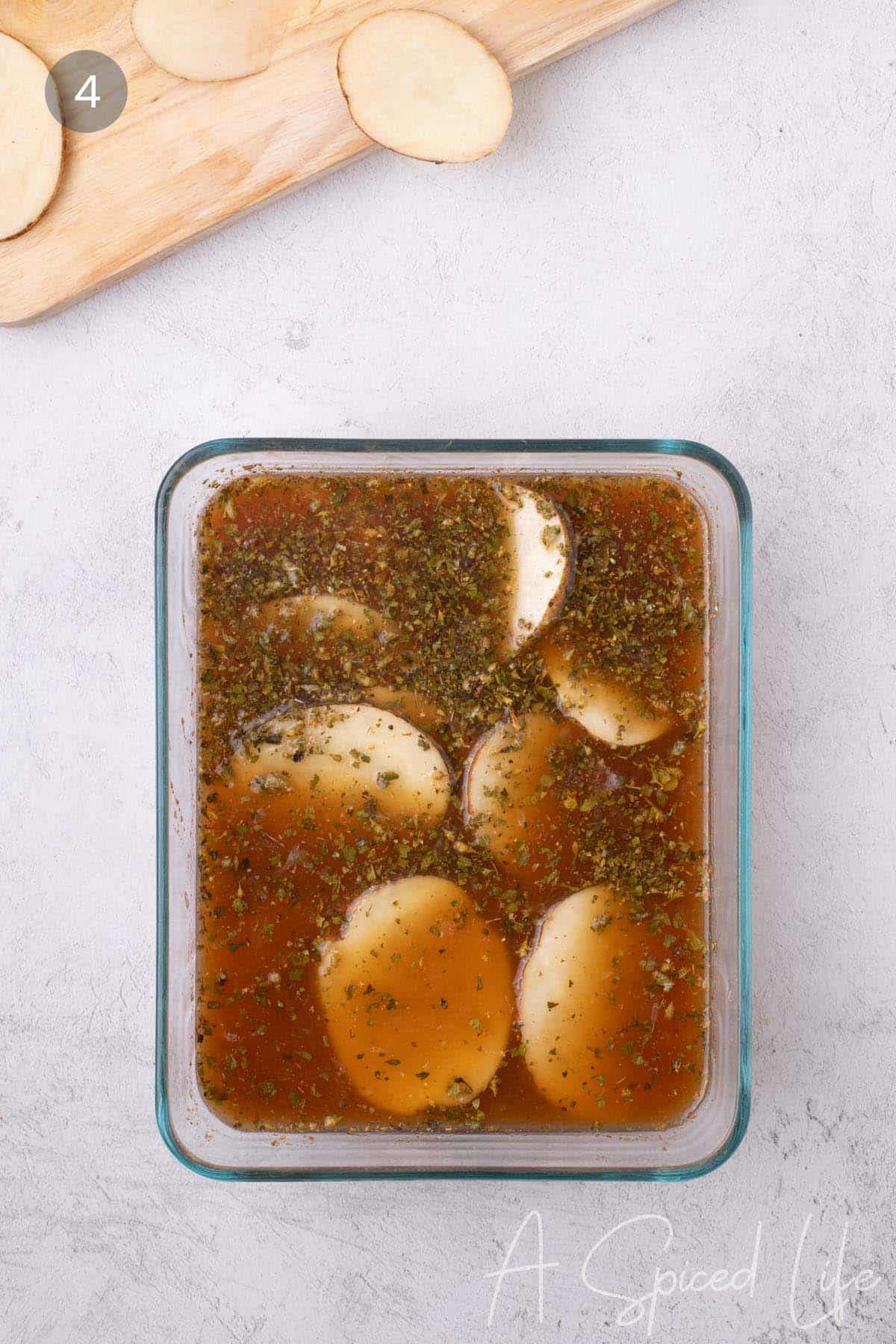 Yukon Gold potato slices coated in a lemon, oregano, and garlic marinade before microwaving.