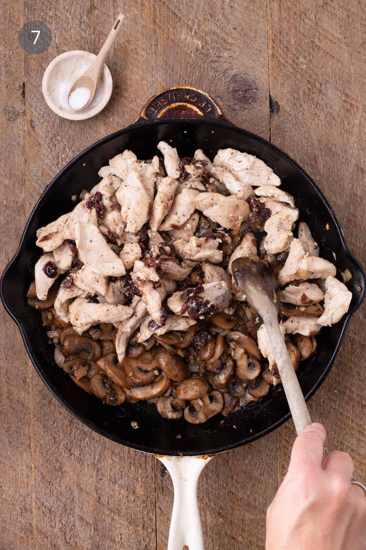 Cooked chicken and cranberries returned to the skillet with the mushroom mixture for warm chicken and rice salad.